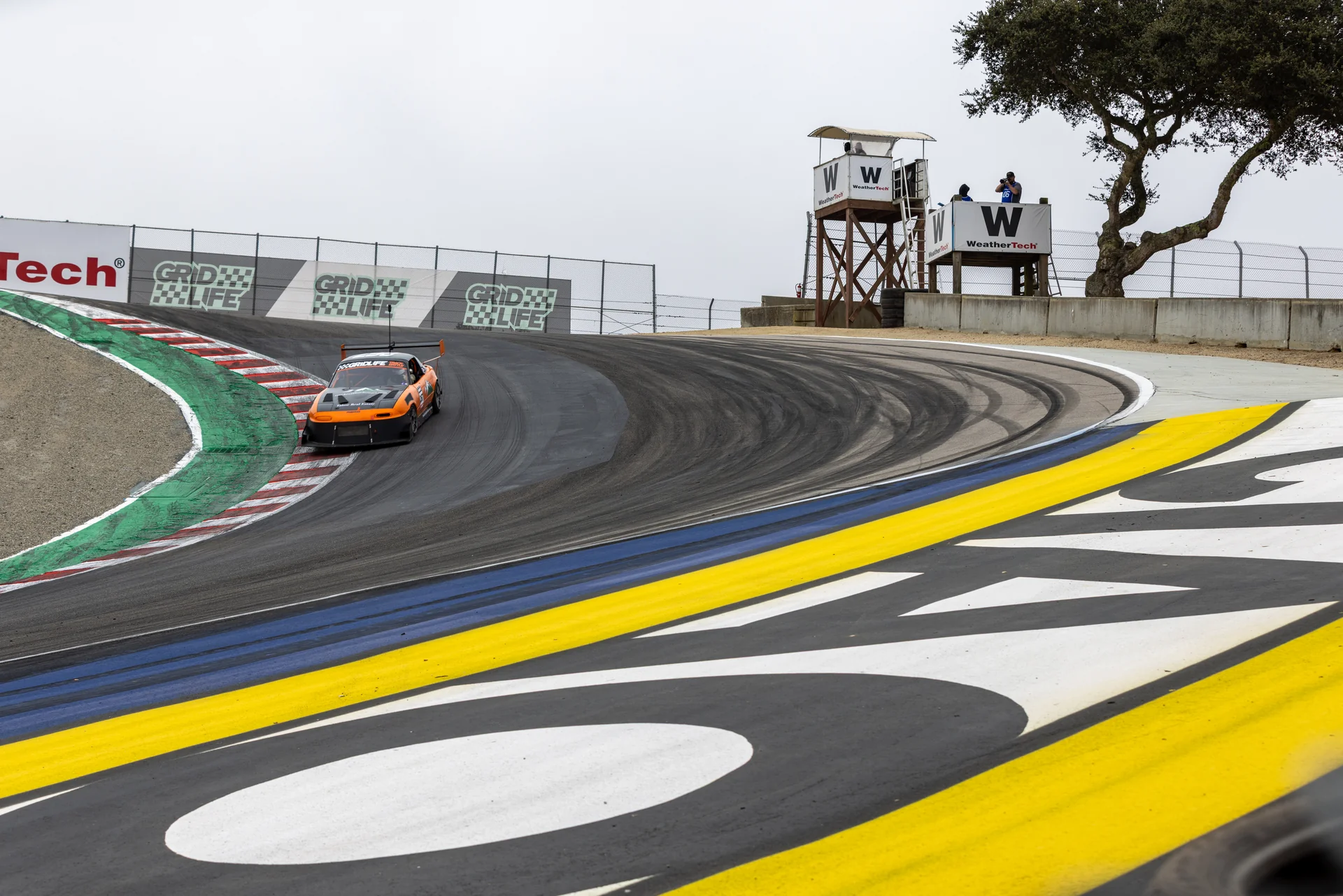 Orange Buchanan Racing number 267 Miata descending the Corkscrew at Laguna Seca