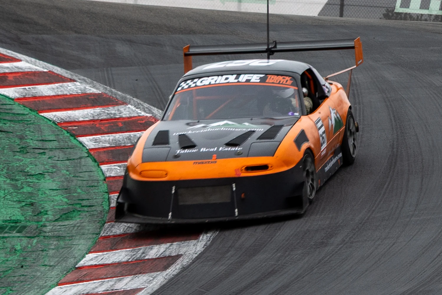 Close view of the Miata's front aero and tires as it descends the Corkscrew