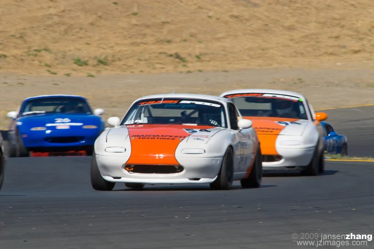 White and orange number 94 Miata in wheel-to-wheel racing from Nick’s racing archive