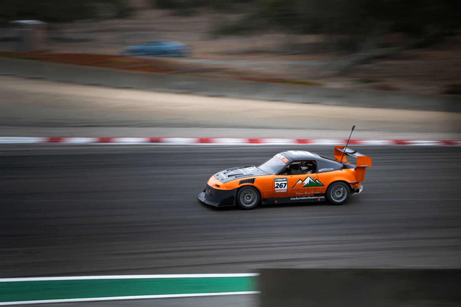 The orange number 267 LS Miata at speed at Laguna Seca